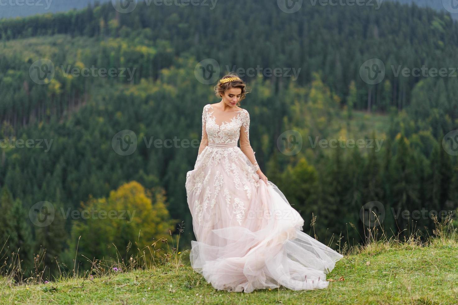 The bride in a pink airy dress swirls and plays with her dress. photo