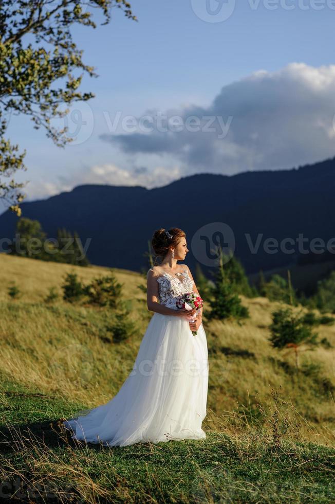 Wedding photography in the mountains. The bride and groom hug tightly. photo