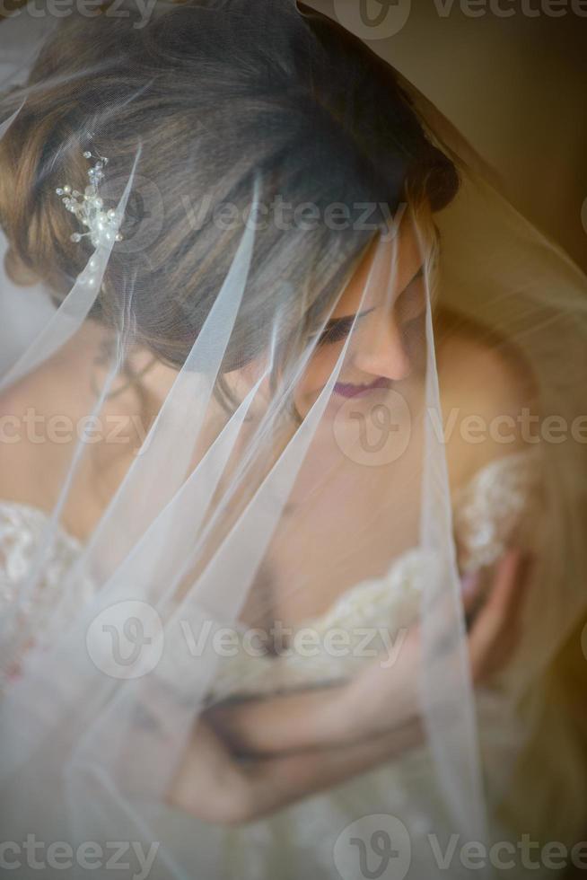 retrato de una bella novia bajo un velo. foto