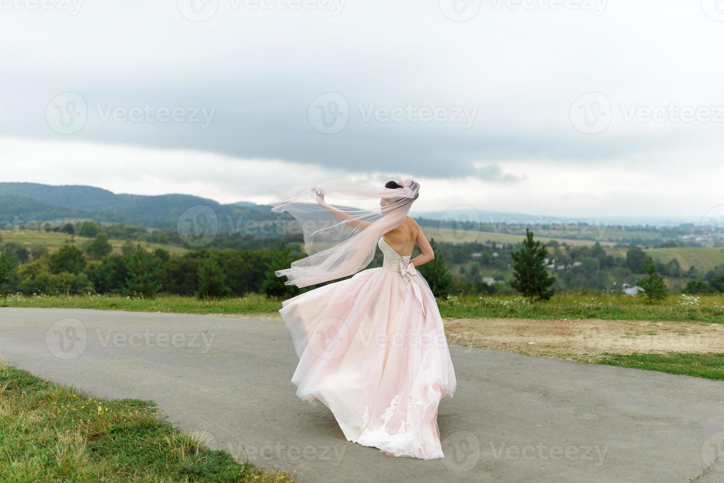 The bride and groom hug under a veil and gently bowed their heads to each other. photo