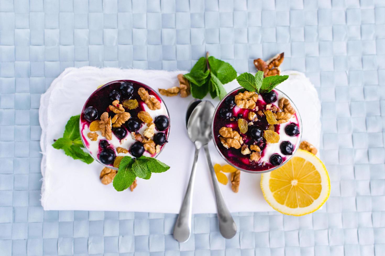 cream dessert with berries, black currant jam and nuts decorated with mint leaves photo