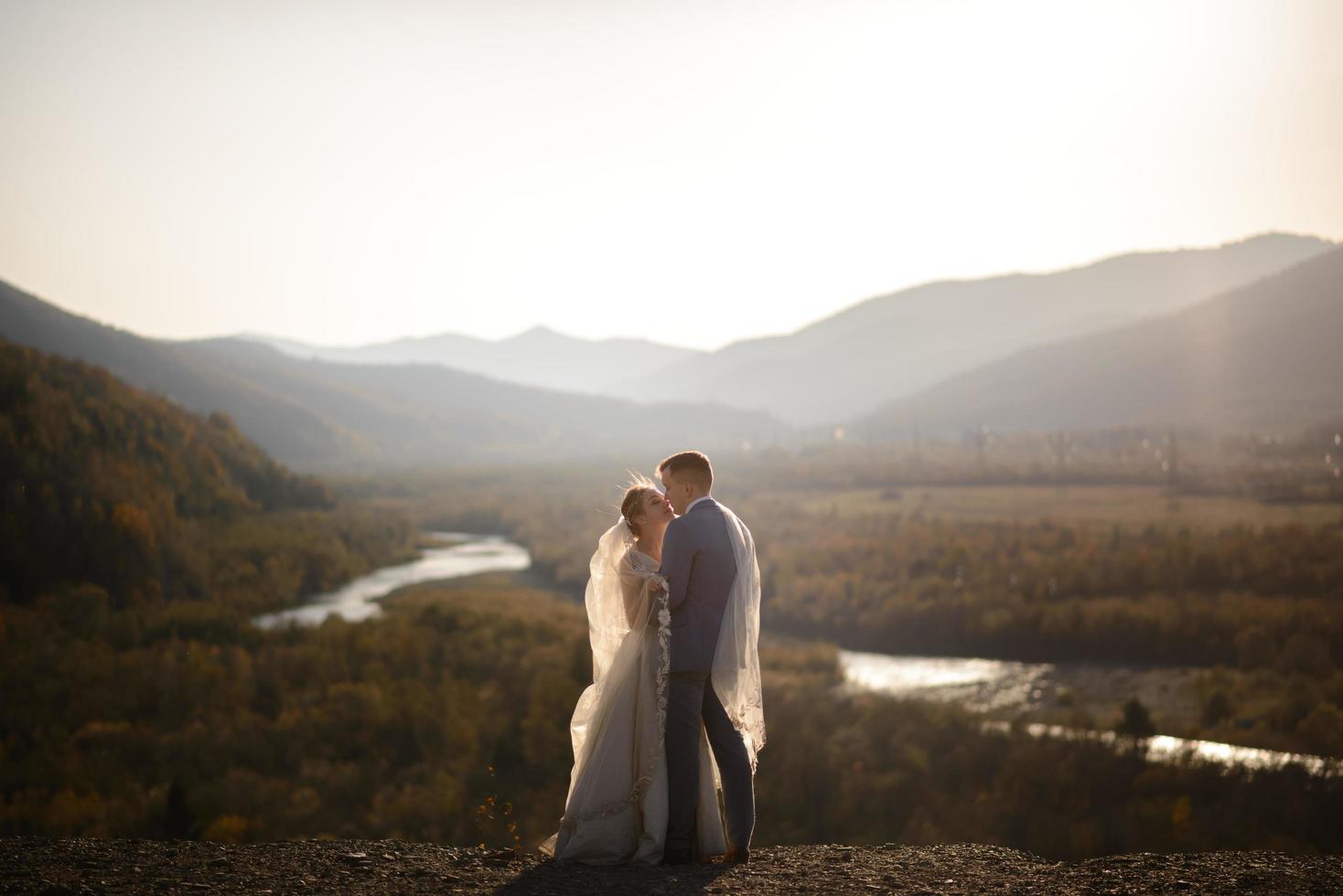 Wedding photo session of the bride and groom in the mountains. Photoshoot at sunset.