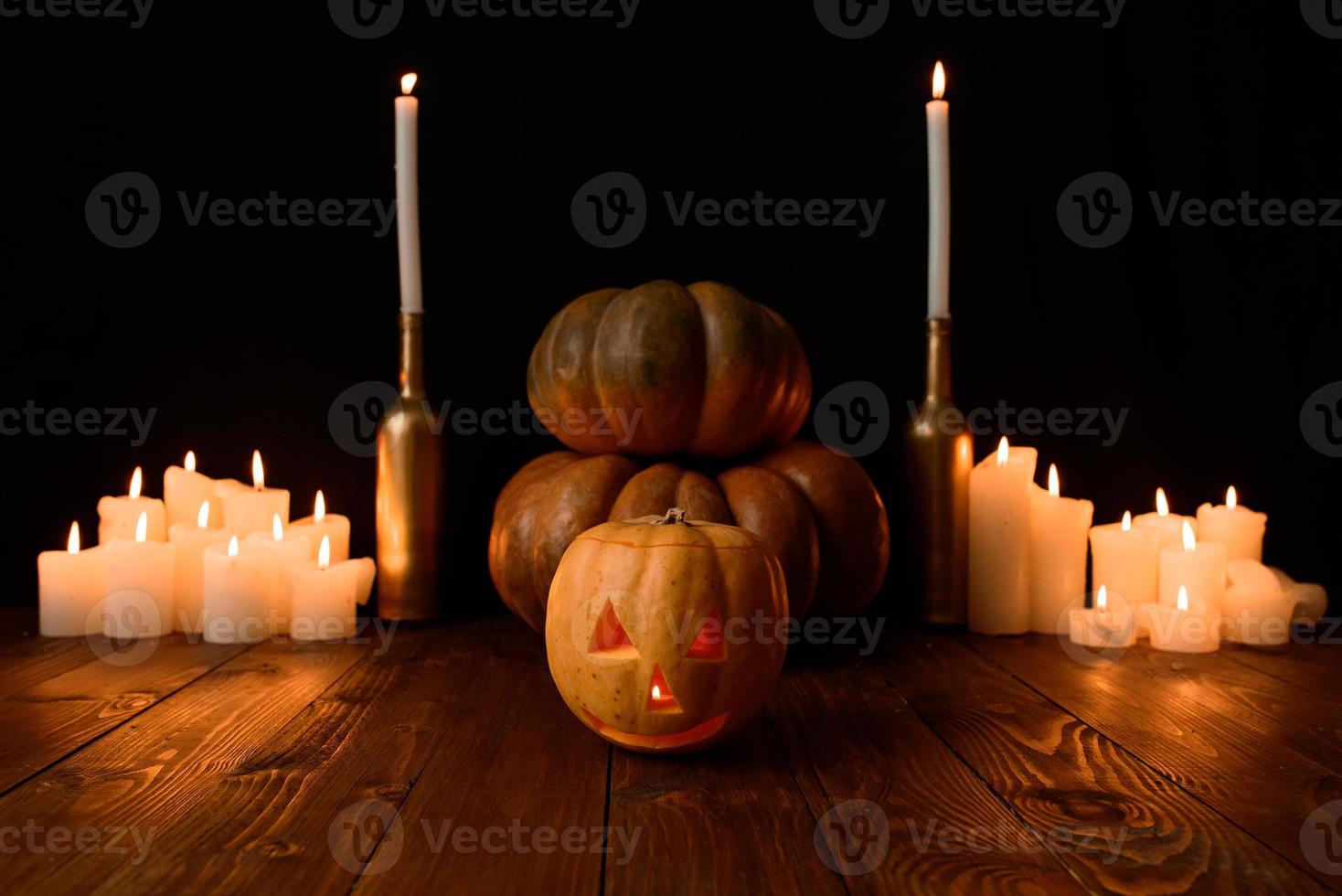 Halloween pumpkin on the background of candles and a black background. photo