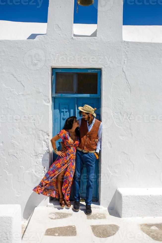 A man and a woman are hugging against the backdrop of Skaros Rock on Santorini Island. The village of Imerovigli. photo