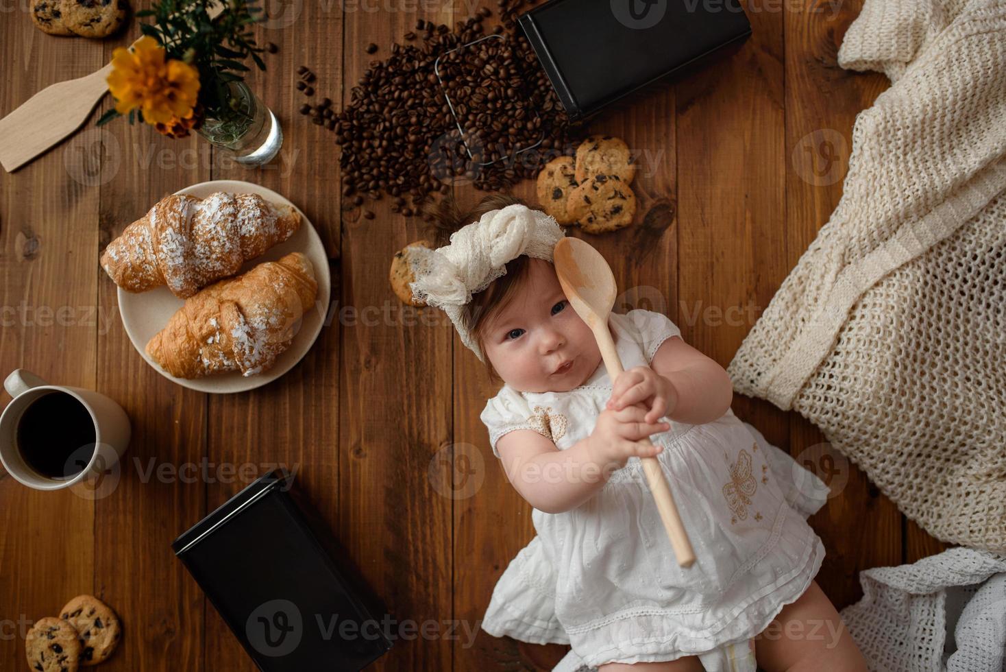 Little girl cook with a wooden spoon is preparing lunch. photo
