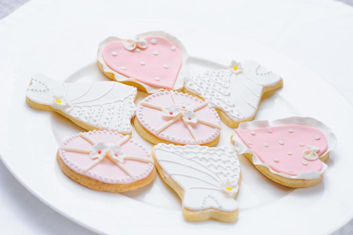 muchas galletas rosas en un plato blanco foto