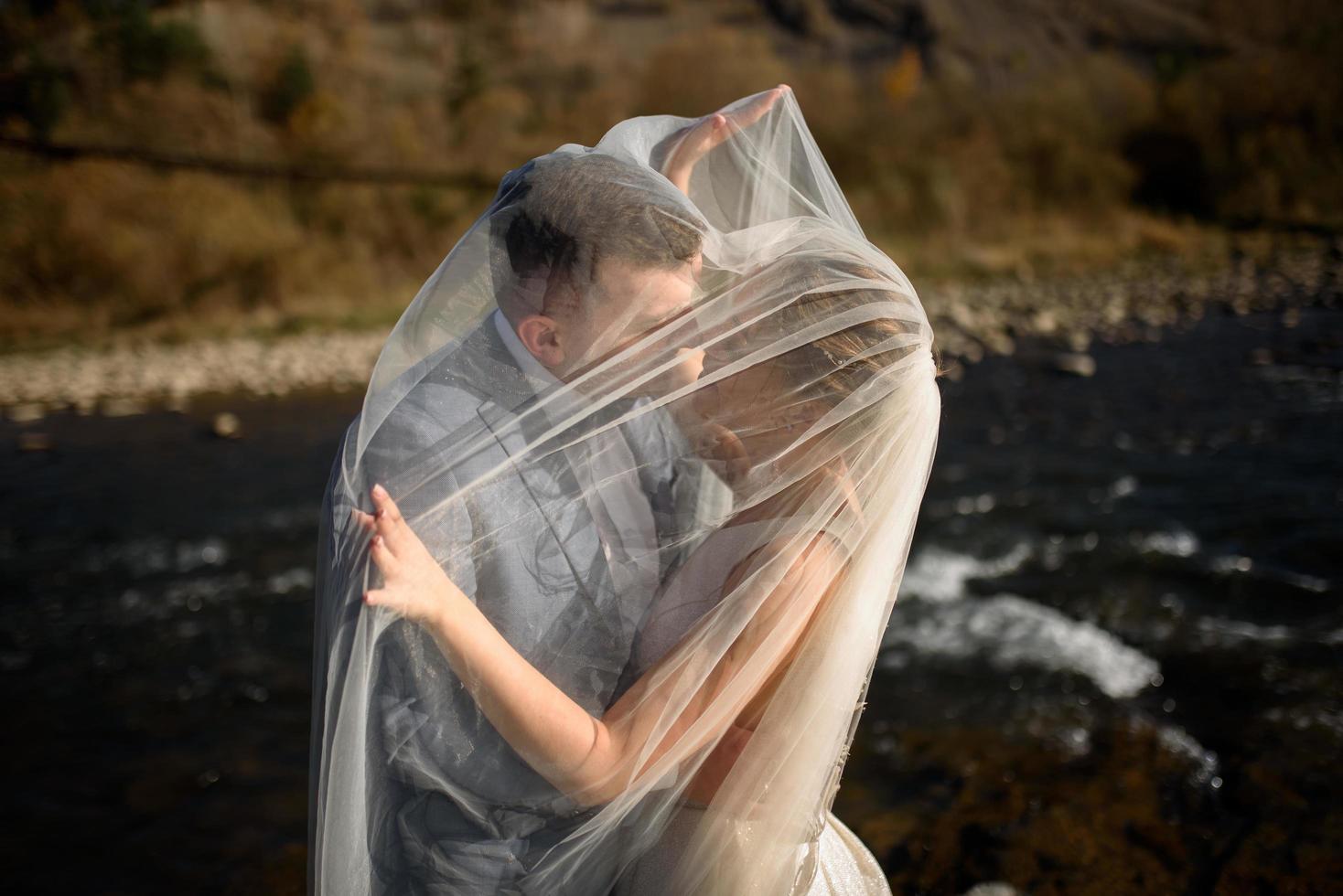 Young beautiful bride take shelter under a photo. Bright backlight shines in the frame photo