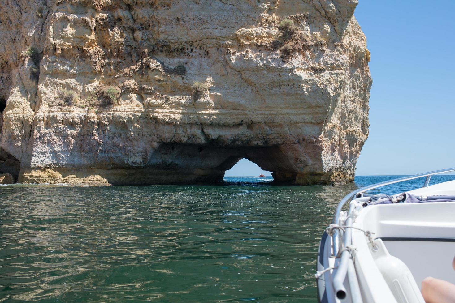 View of the coast at Algarve form a boat. Natural stone arch. Portugal photo