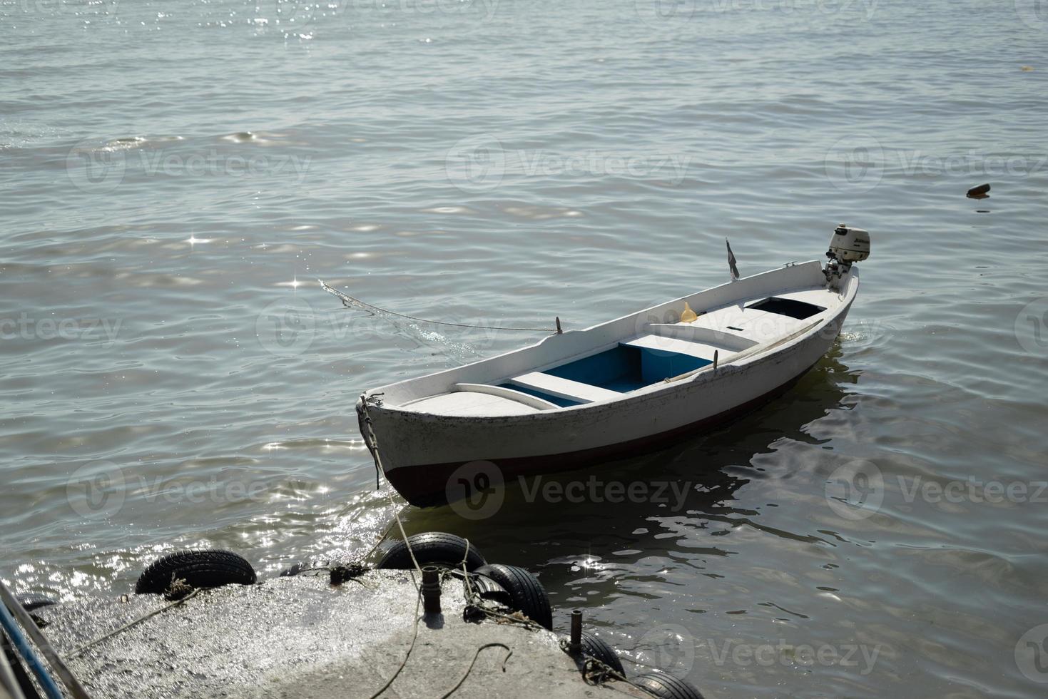 Single boat on sand with sea between circle fecne and beach view with other photo