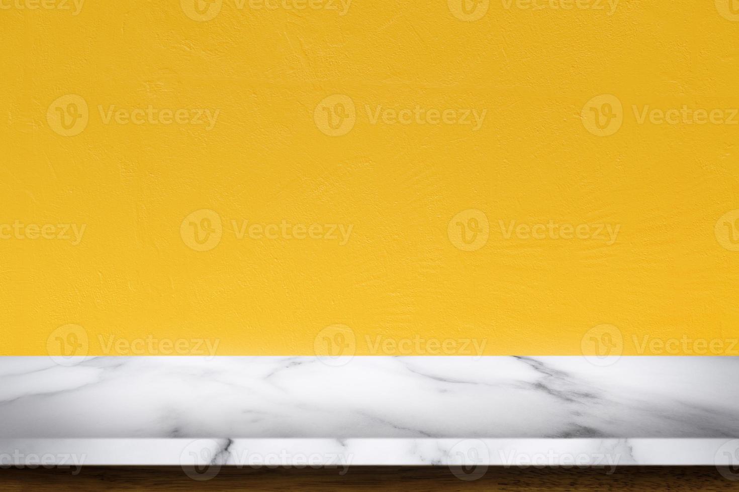 Empty top of white marble table with yellow concrete textured wall background. photo
