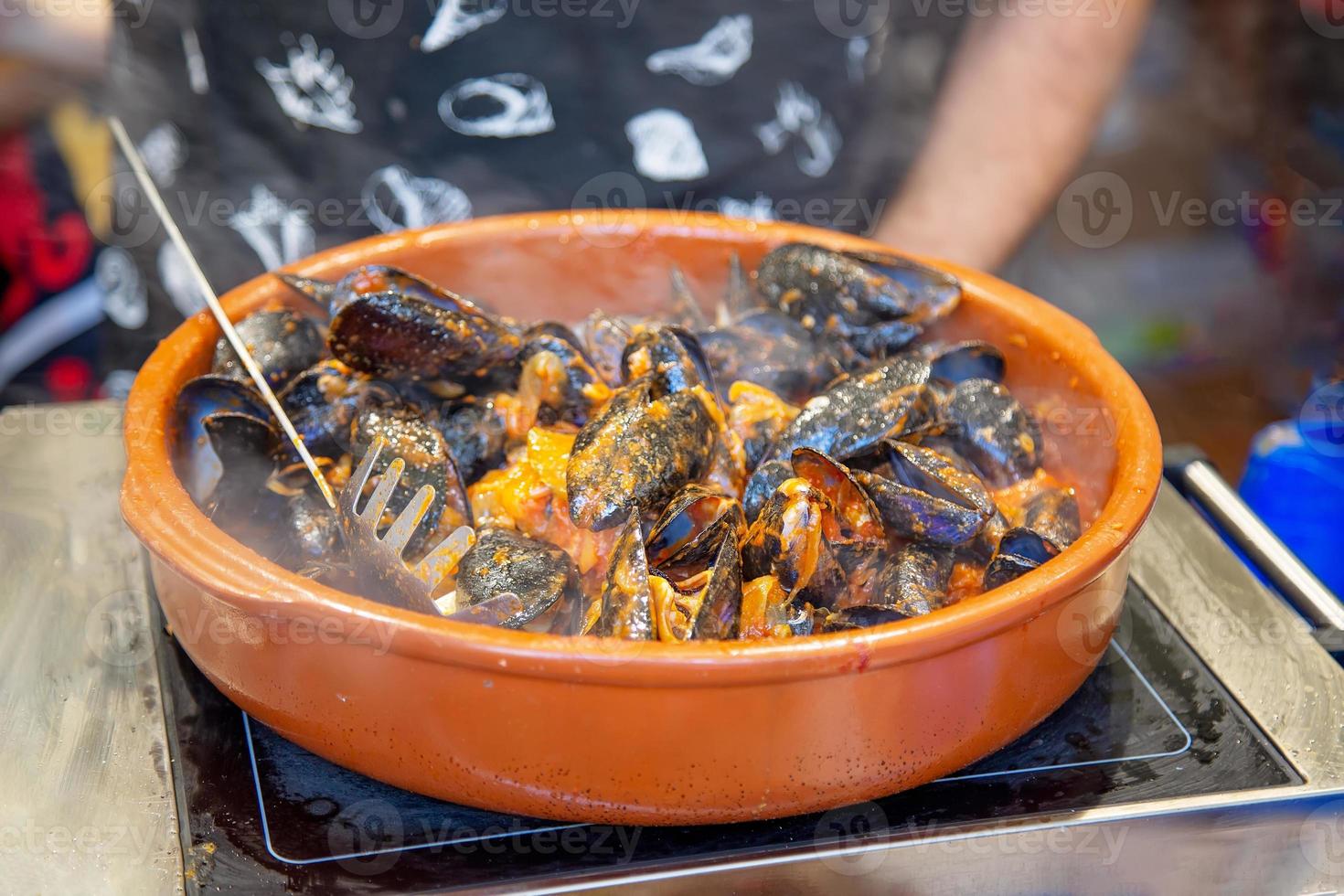 preparación de paella en el mercadillo de las ramblas, cerca de la plaza de la catedral de barcelona foto