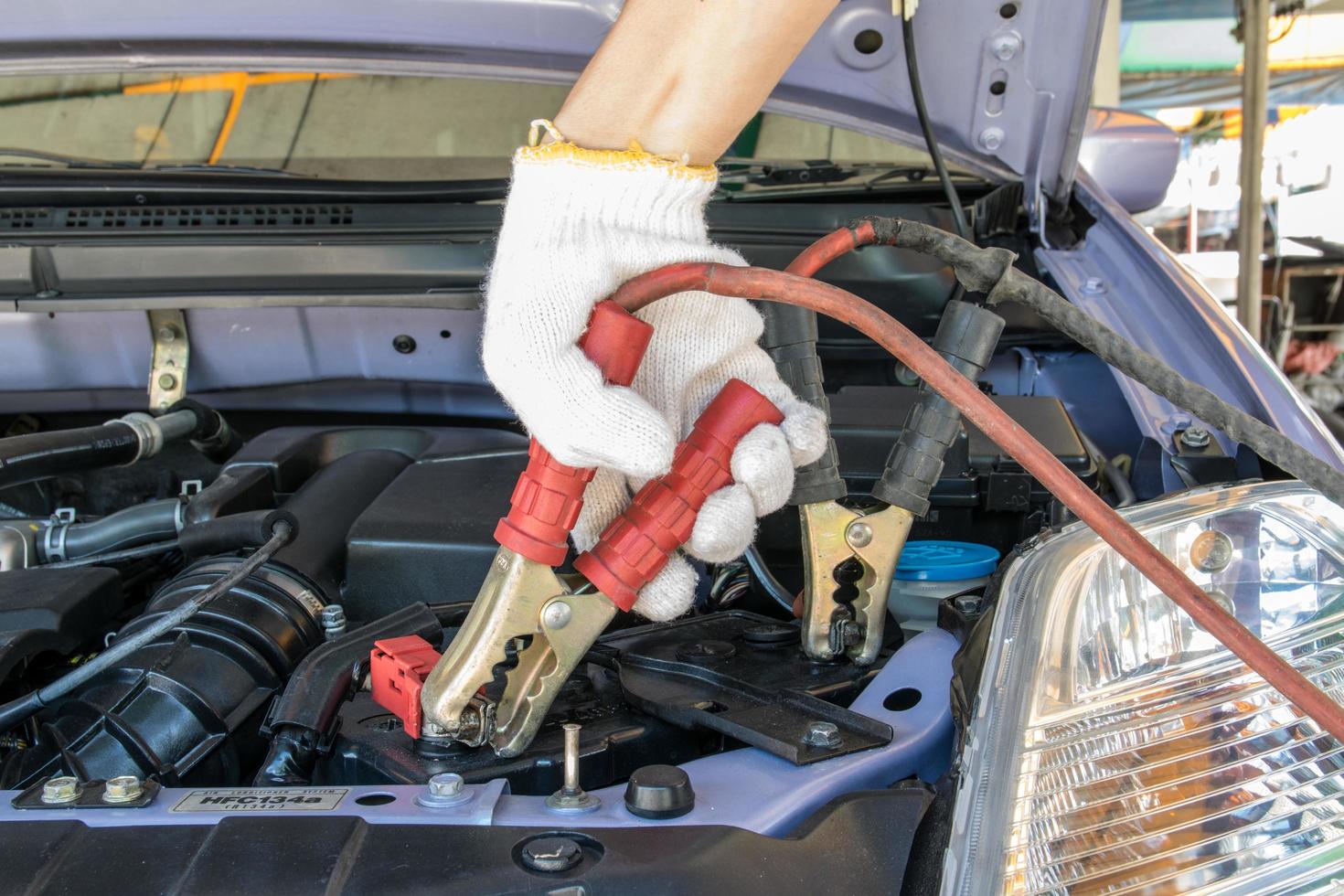 técnico automotriz cargando la batería del vehículo foto