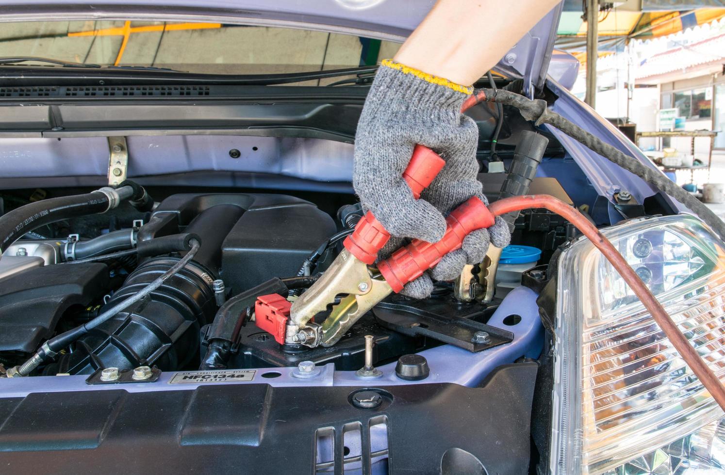 técnico automotriz cargando la batería del vehículo foto