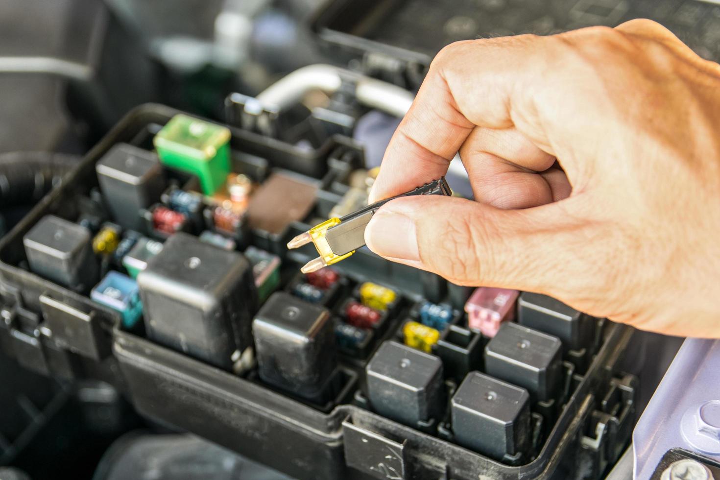 Mecánico de automóviles comprobando un fusible del coche foto