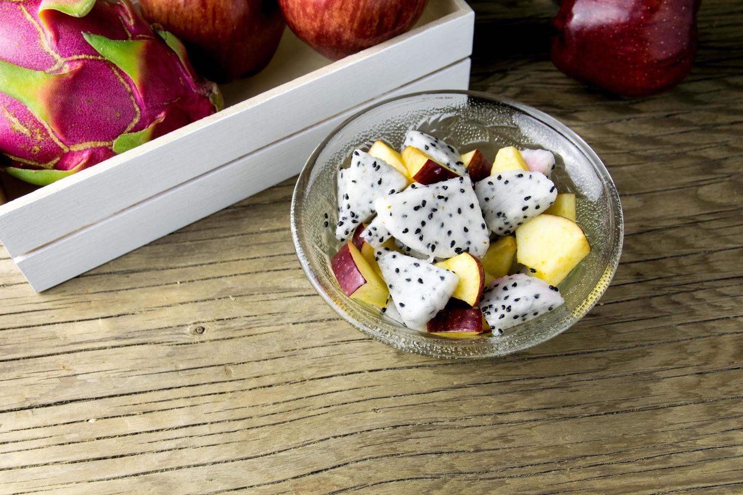 Ensalada de frutas en un recipiente sobre la mesa de madera. enfoque selectivo foto