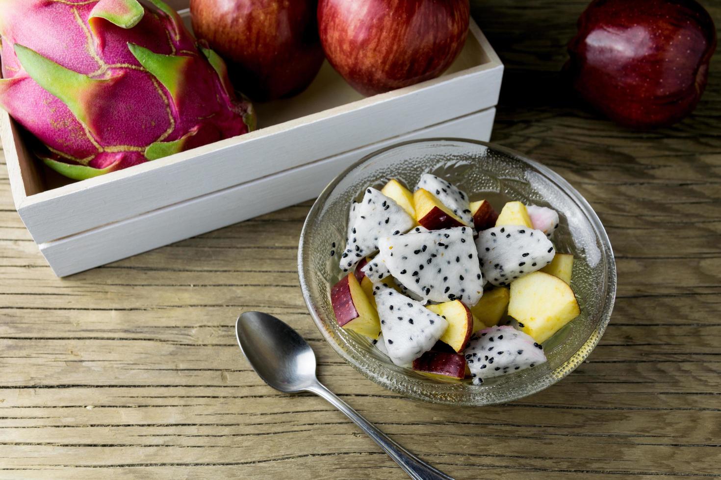 Ensalada de frutas en un recipiente sobre la mesa de madera. enfoque selectivo foto