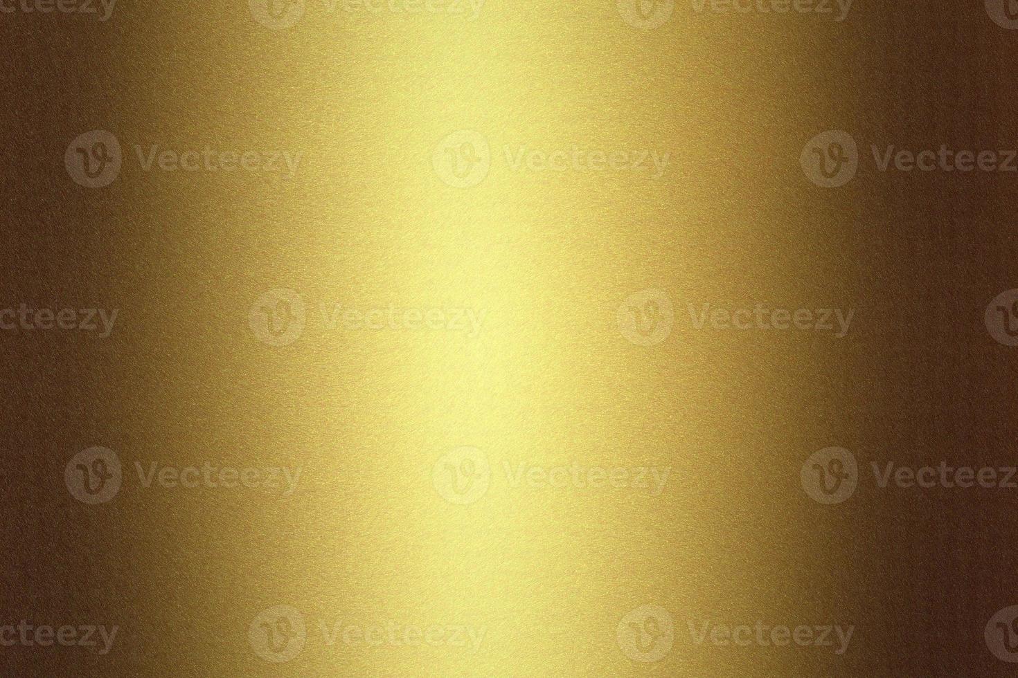 Light shining on golden metallic plate in dark room, abstract texture background photo