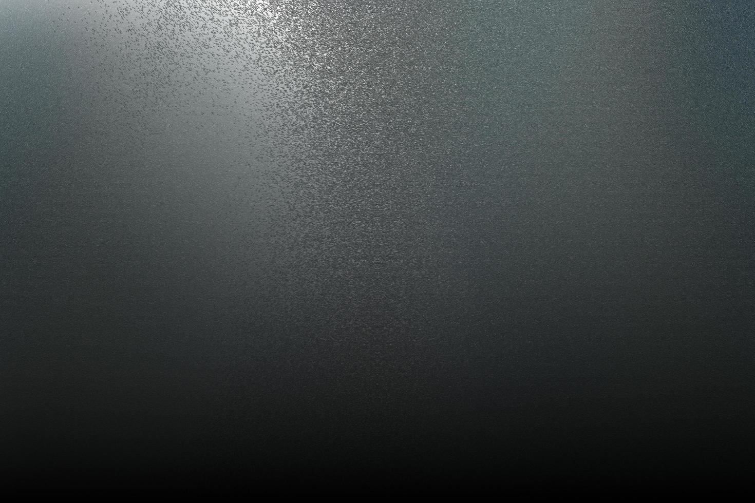Texture of rough gray metallic wall in dark room, abstract background photo