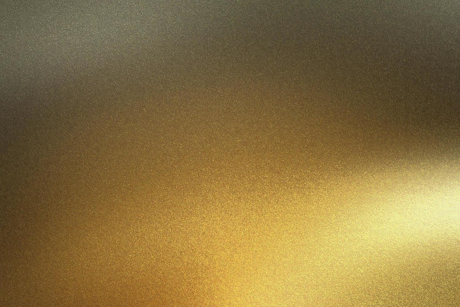 Light shining on golden metal foil in dark room, abstract texture background photo