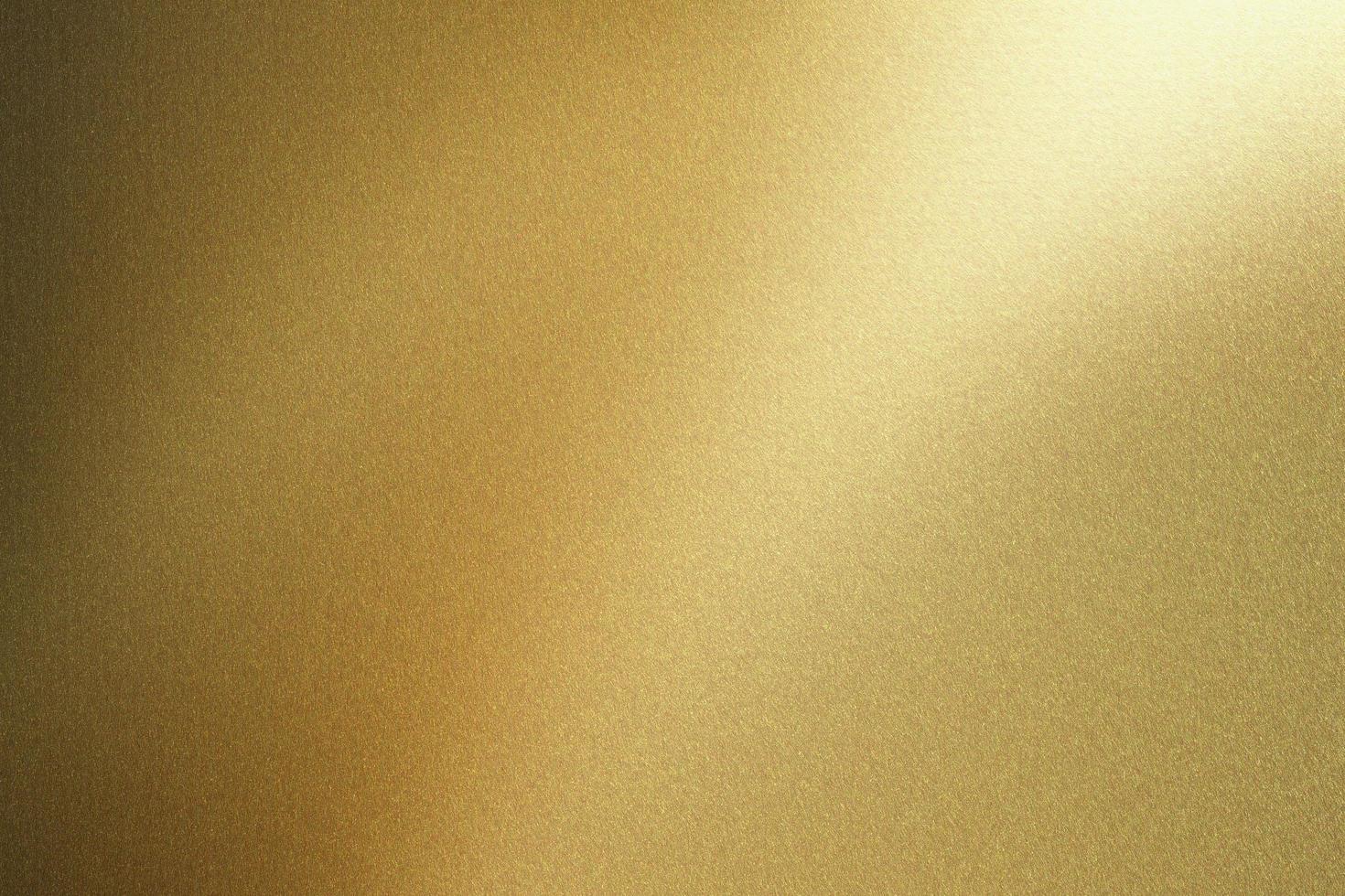 luz que brilla en la pared de acero dorado, fondo de textura abstracta foto