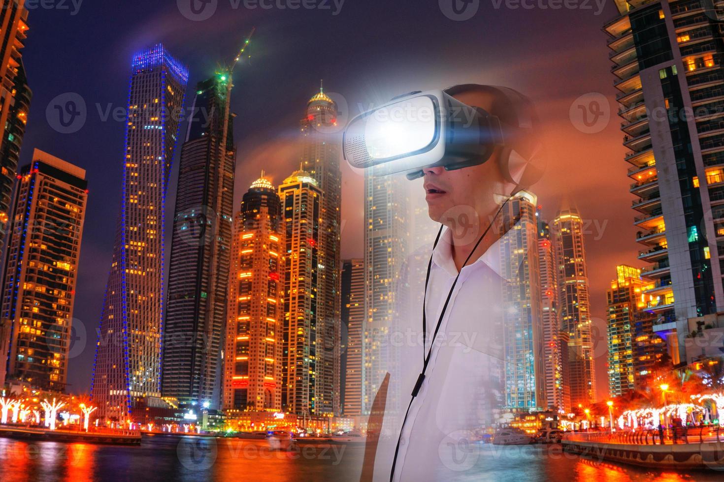Defocus overlapping image of a man wearing virtual reality glasses and a modern building. Metaverse digital cyber technology concept. Future digital technology cyber virtual game entertainment. photo