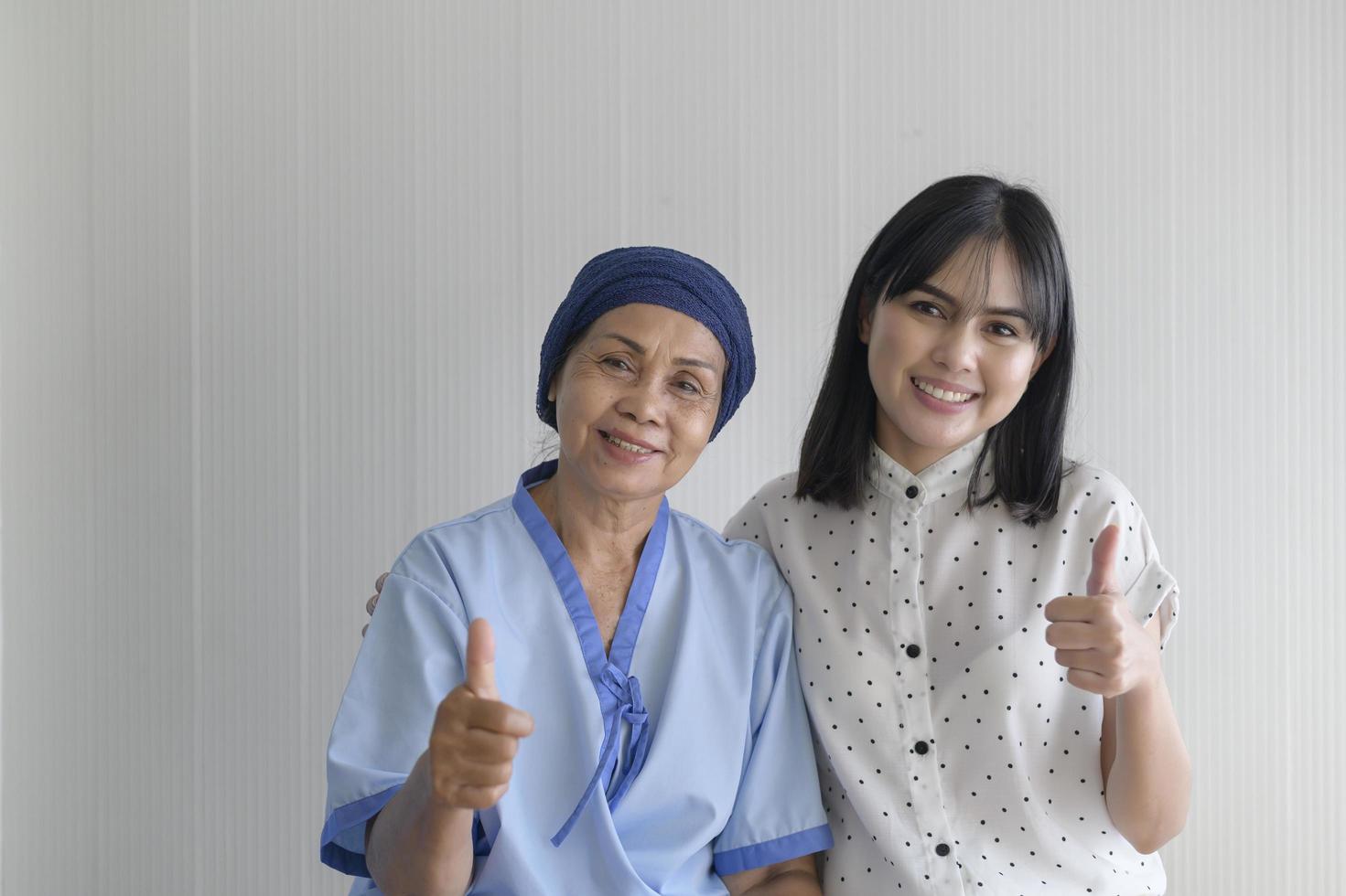 mujer paciente con cáncer con pañuelo en la cabeza y su hija solidaria en el concepto de hospital, salud y seguro. foto