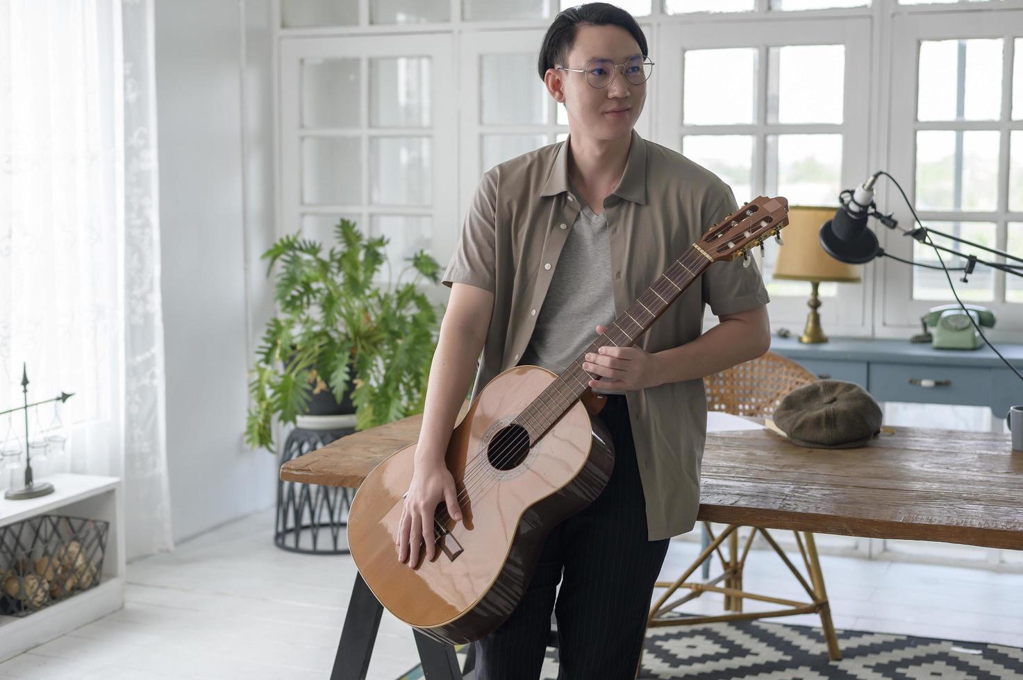 retrato, de, un, músico, hombre, tenencia, guitarra, en, casa, estudio foto