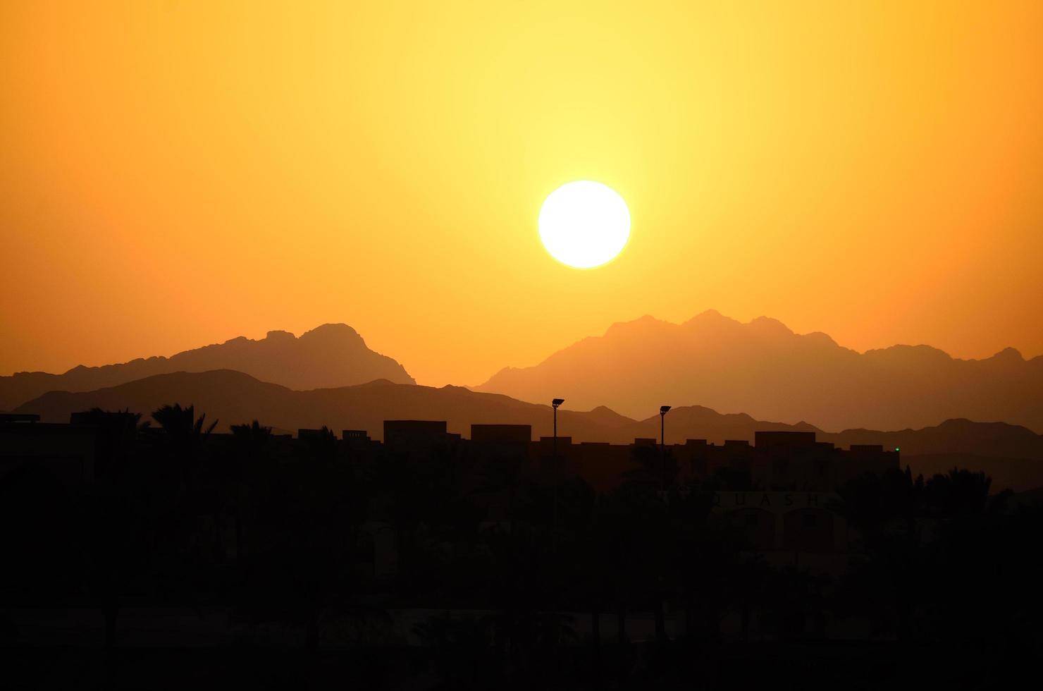 sunset with mountains and houses photo