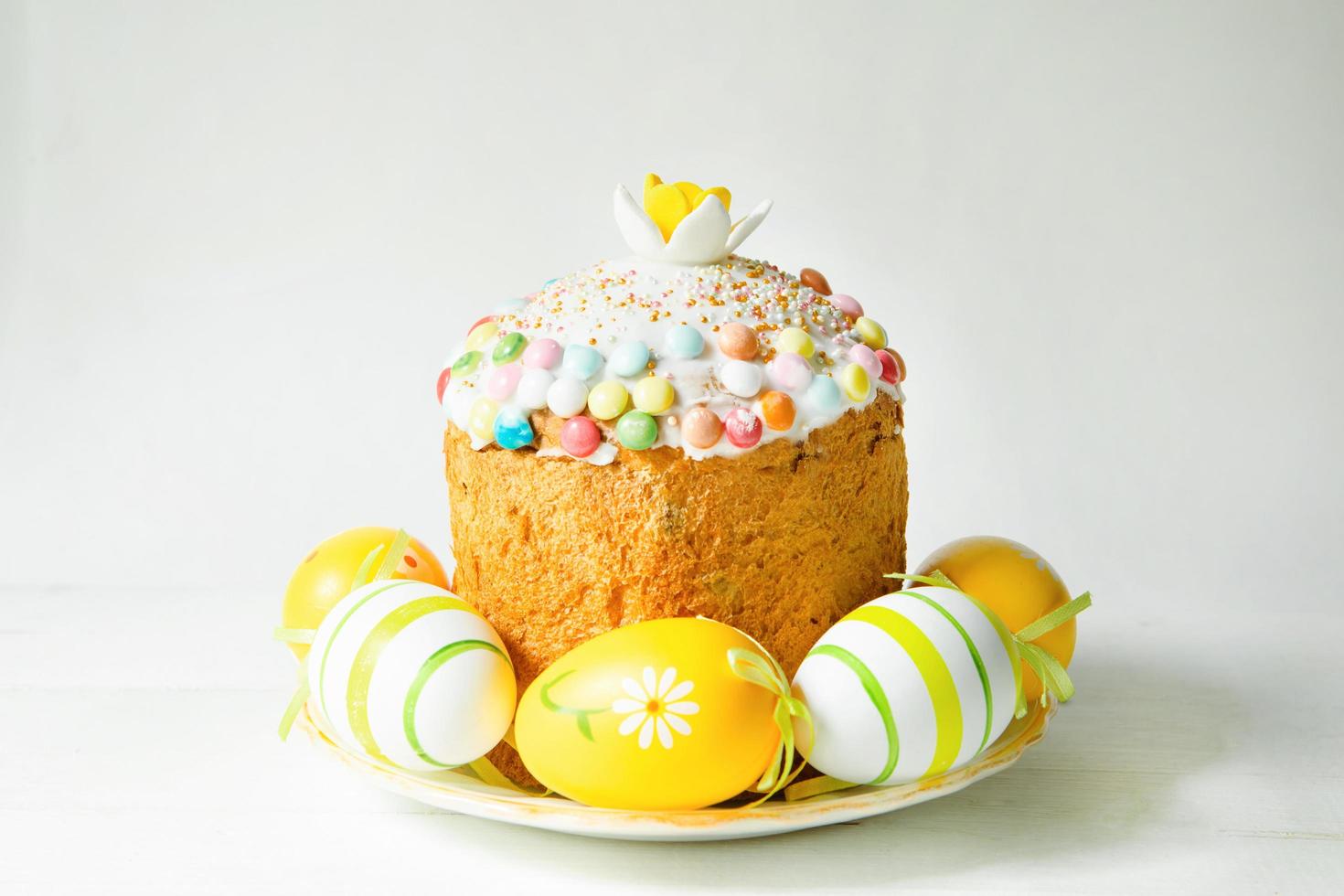 Easter cake with painted eggs on a platter in a gray interior. Traditional festive food photo