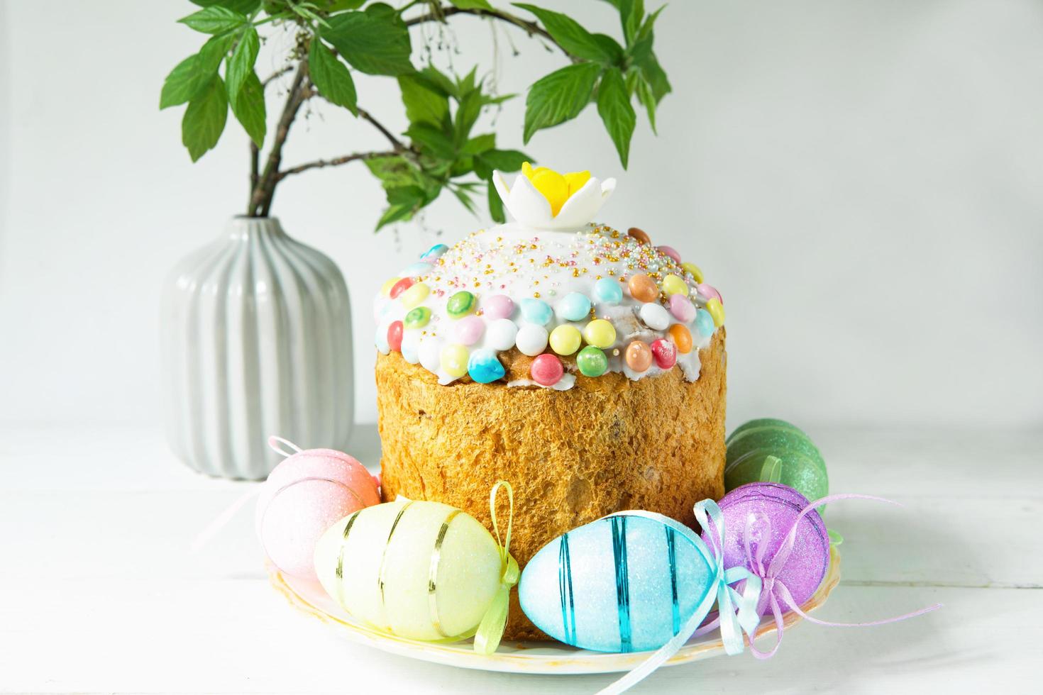 Easter cake with painted eggs on a platter in a gray interior. Traditional festive food photo