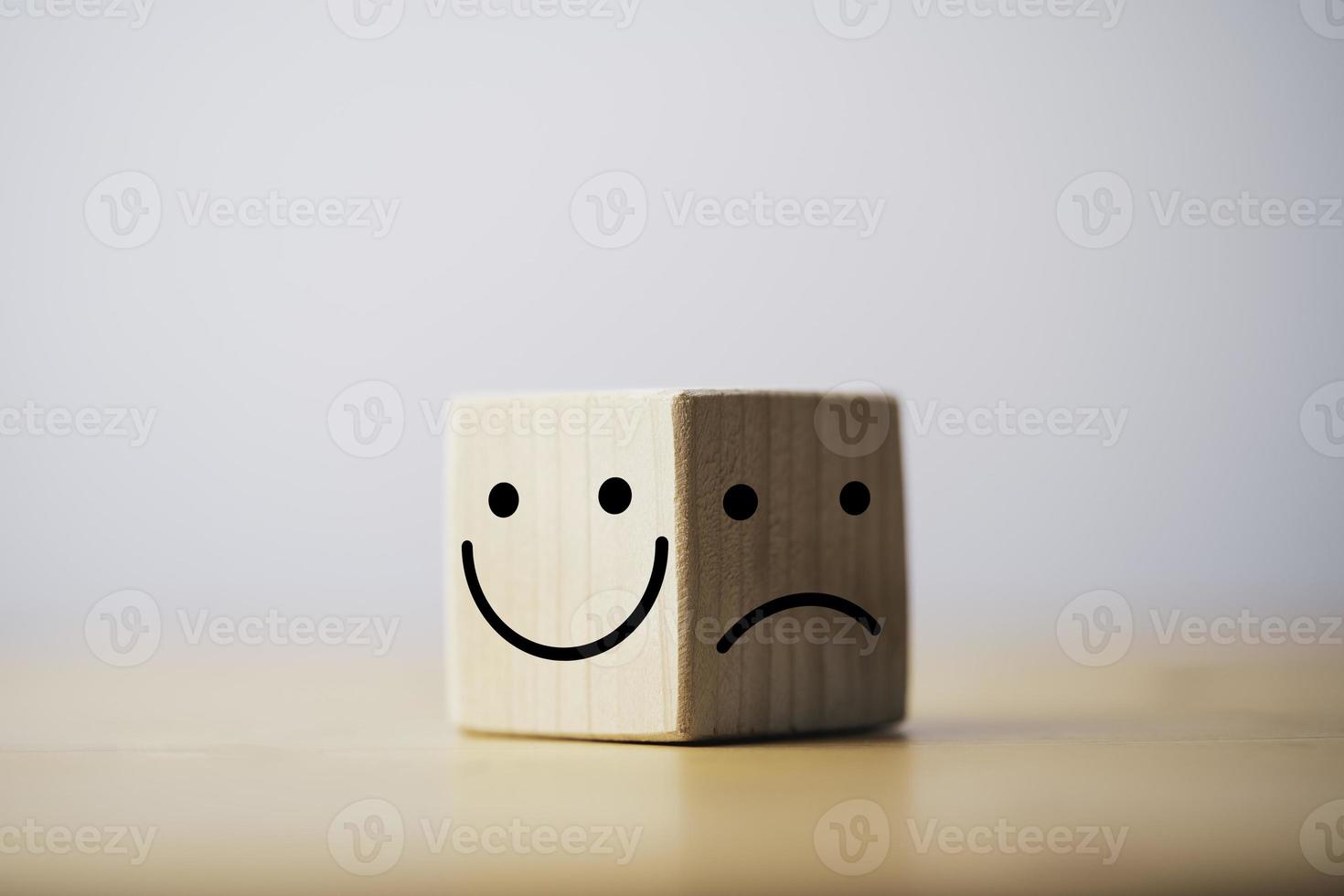 Smile face in bright side and sad face in dark side on wooden block cube for positive mindset selection concept. photo