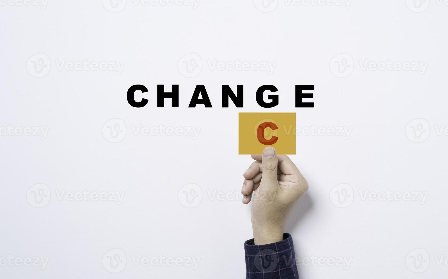 mano sujetando una tarjeta amarilla con el alfabeto c para convertir el cambio en una redacción aleatoria sobre fondo blanco para un concepto de pensamiento de mentalidad positiva. foto