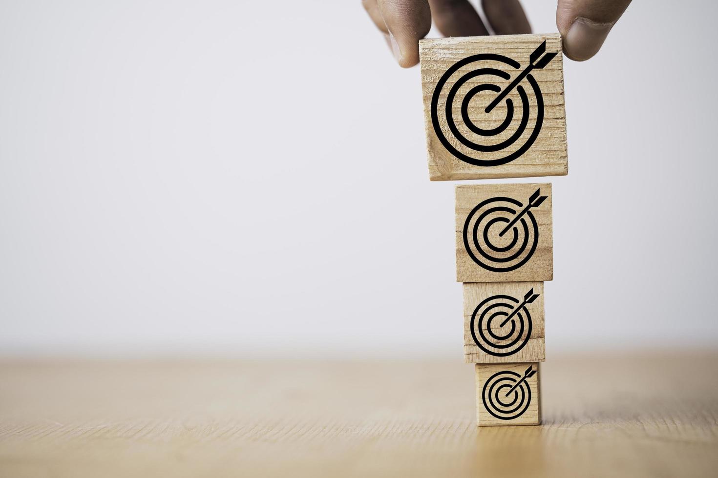 Han putting the biggest target board on wooden block for enhance business objective target concept. photo