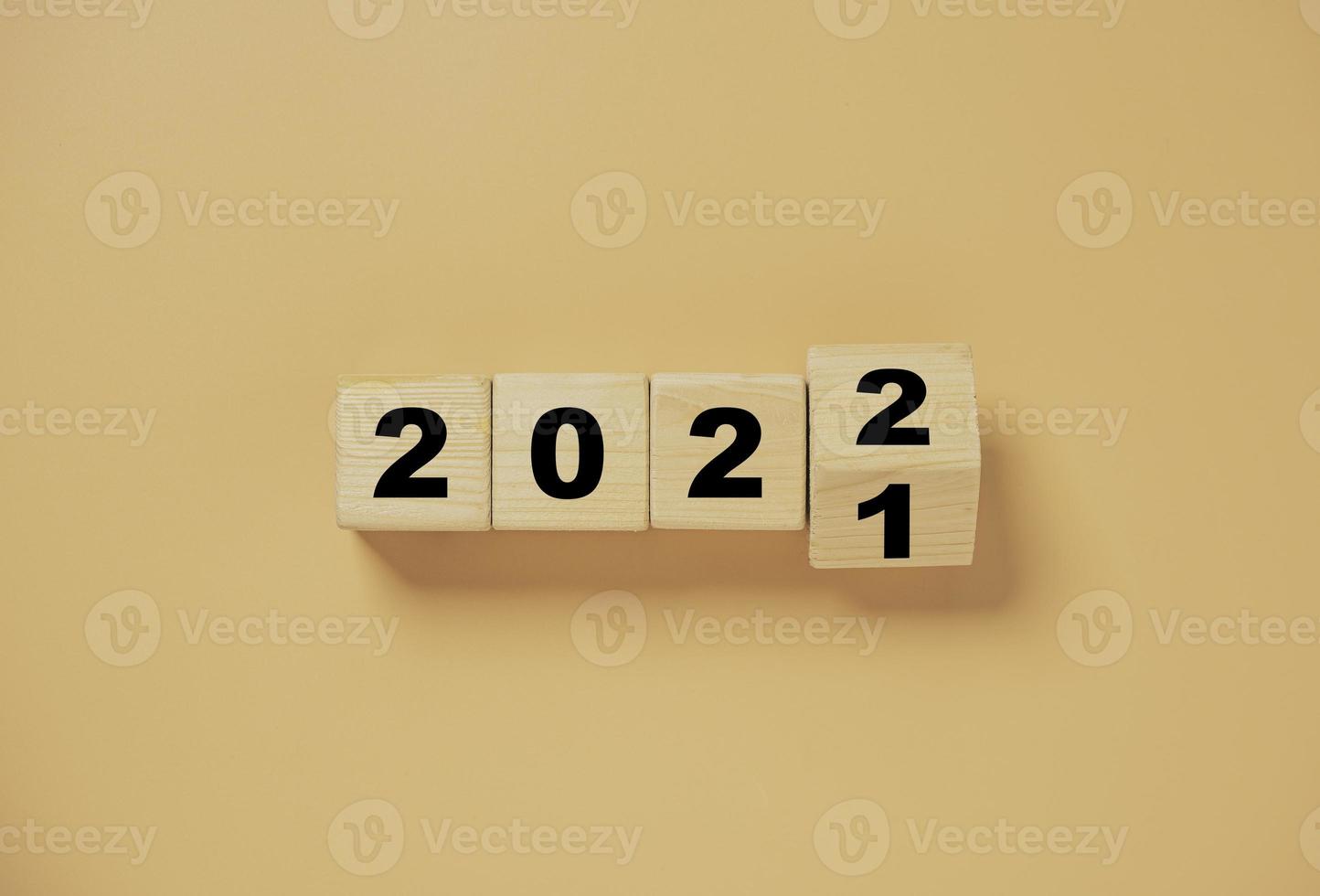 Wooden cube block flipping from 2021 to 2022 on orange background , preparation for merry Christmas and happy new year. photo