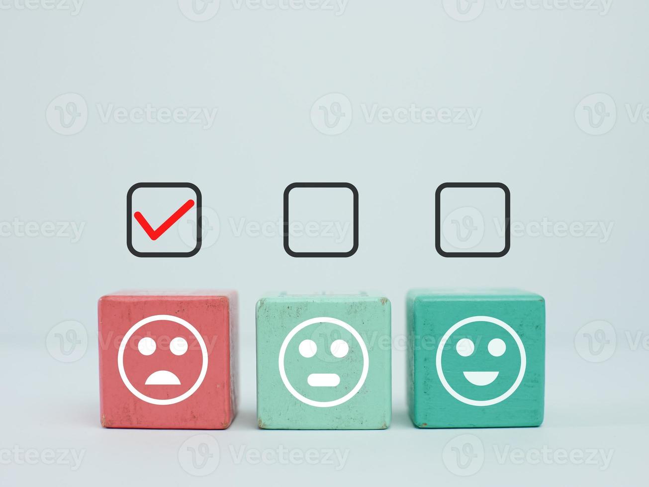 sad face in wooden block with check mark for bad feedback rating and negative customer review photo