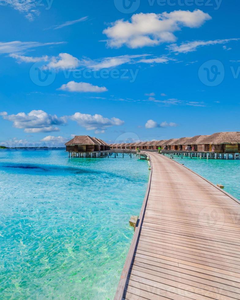 Luxury hotel or resort on a tropical beach, water villas, bungalows wooden jetty. Luxury spa and well being background. Summer paradise island, exotic travel landscape, seascape photo