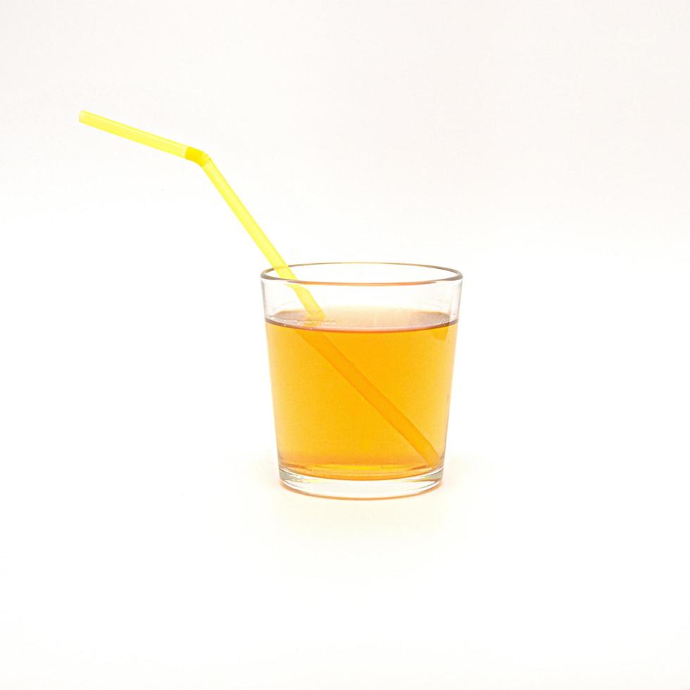 un vaso de jugo de manzana con una pajita aislado en un fondo blanco foto