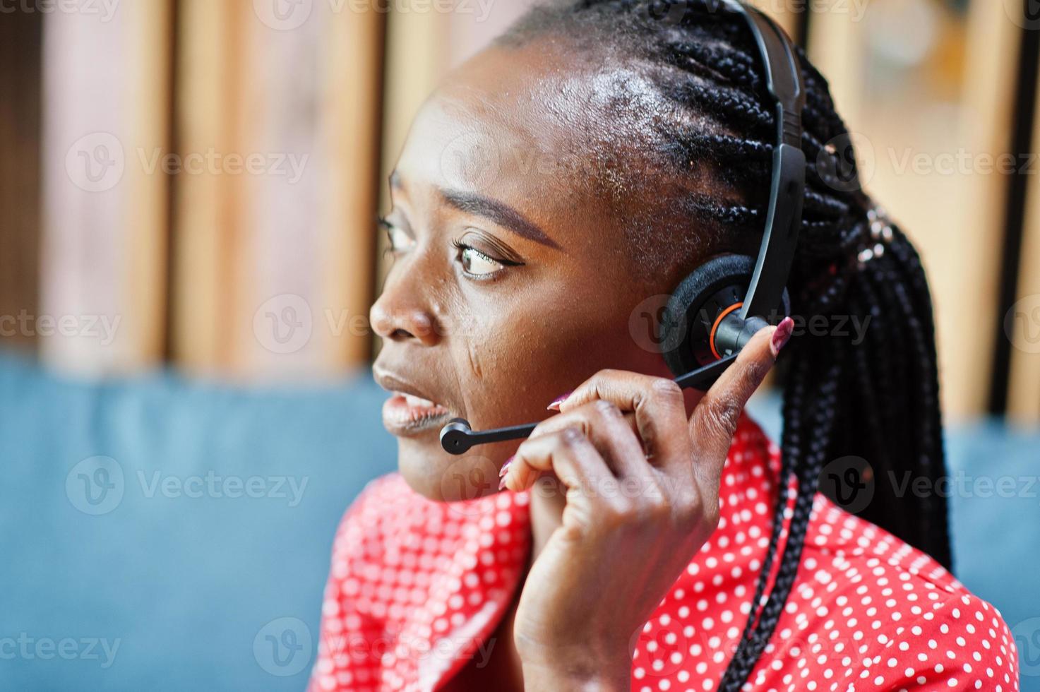 African american woman works in a call center operator and customer service agent wearing microphone headsets working on laptop. photo