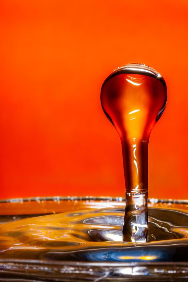 Water droplet against orange coloured card photo