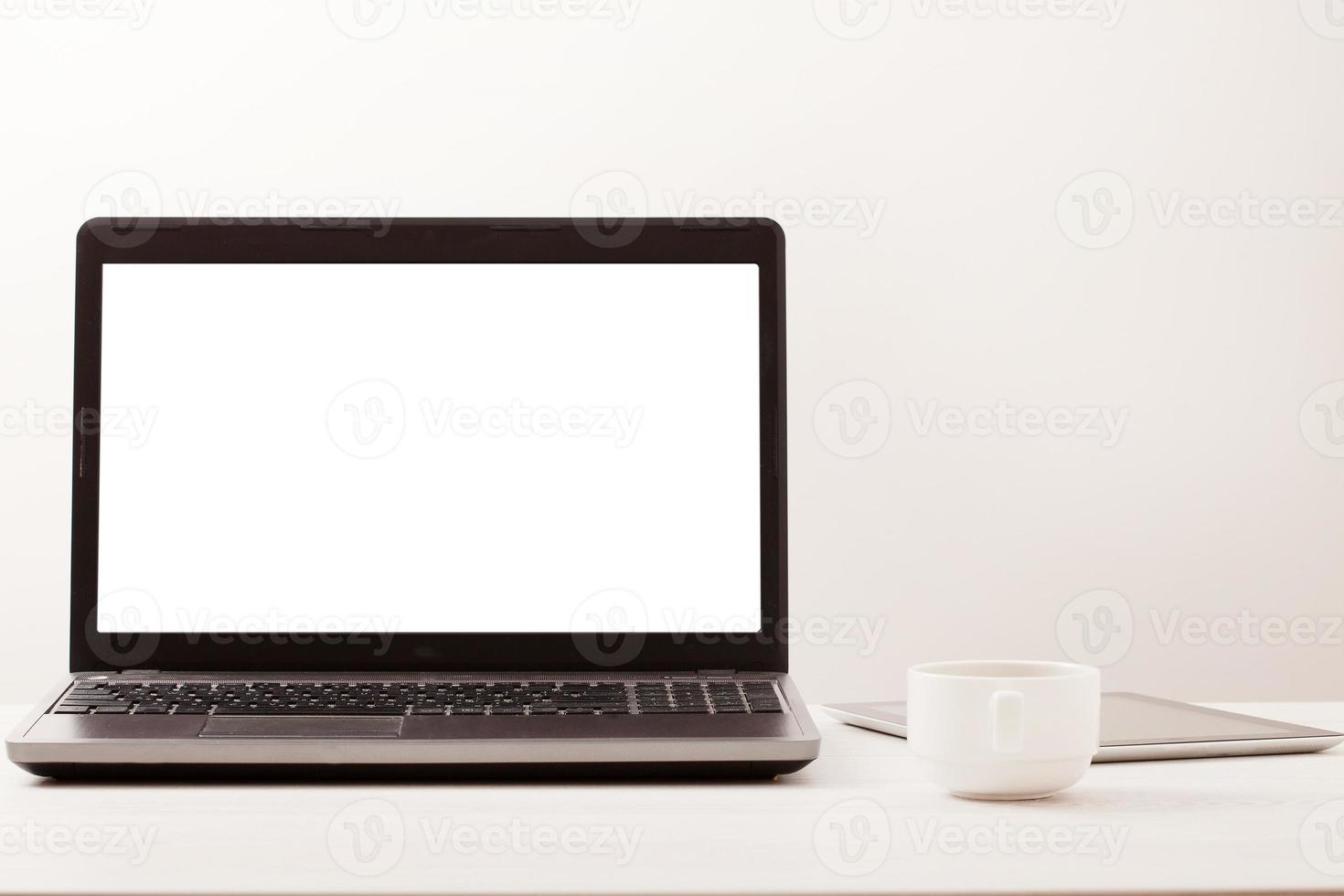 Laptop with blank screen on workplace. Empty space desk white office Interior. Copy space. Business concept. photo