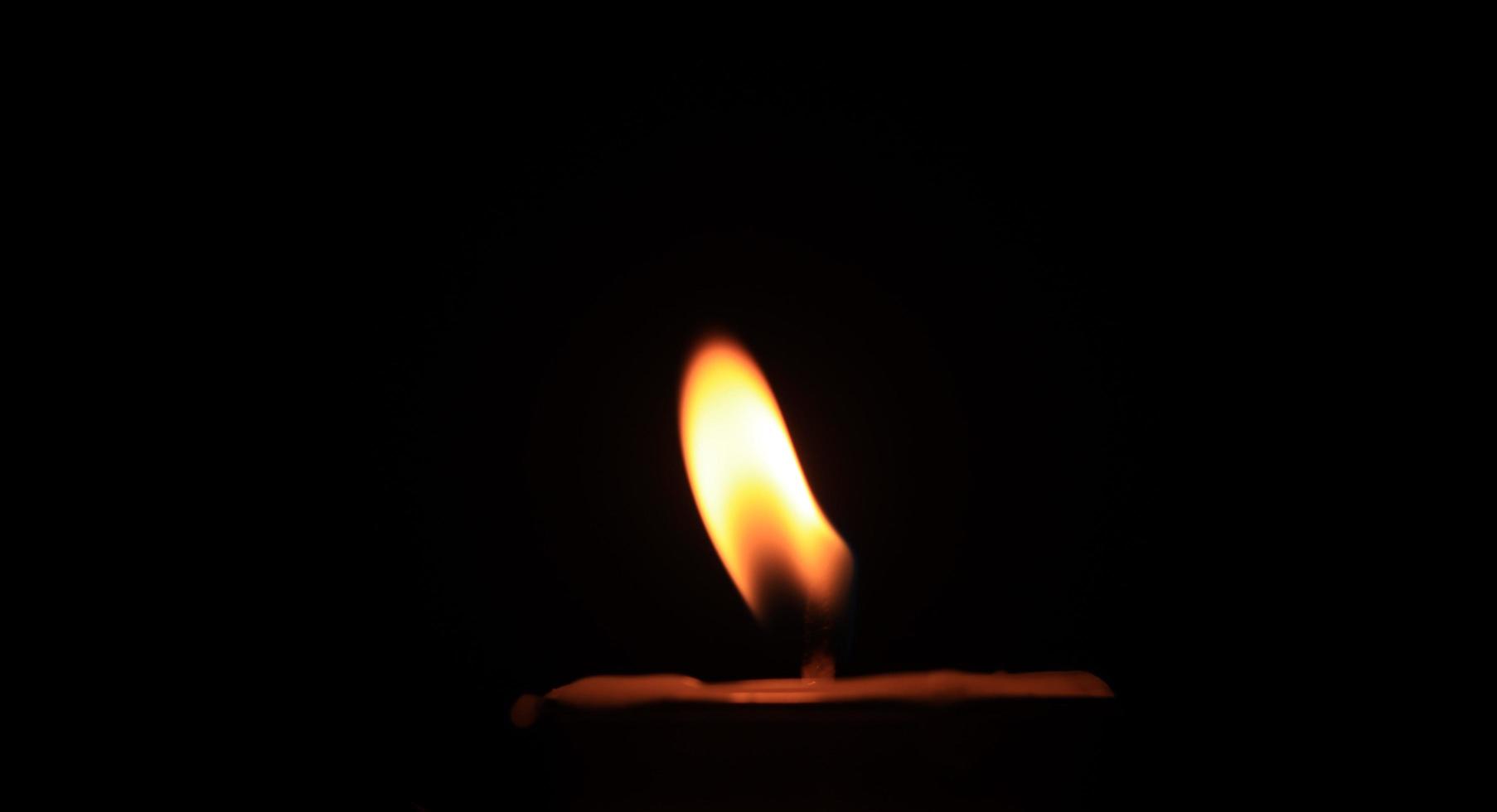 Candle flame on a black background religious ceremony photo