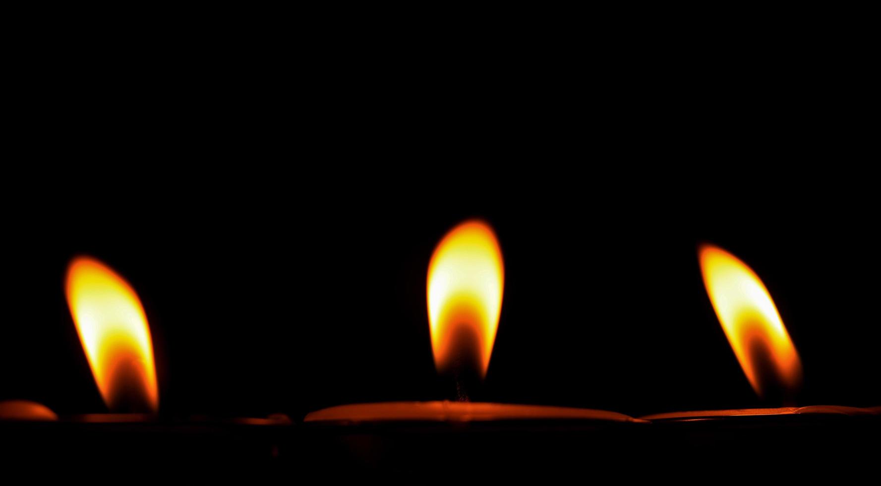 Candle flame on a black background religious ceremony photo