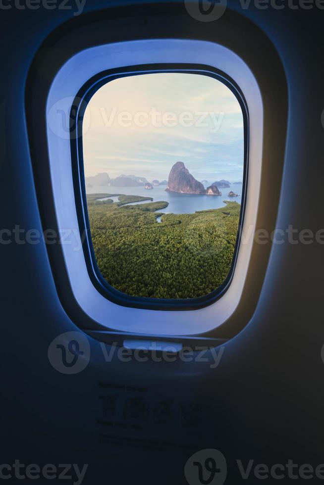 Concept image of touring and transportation, airplane's window with Samed Nang Shee ariel view in Thailand. photo