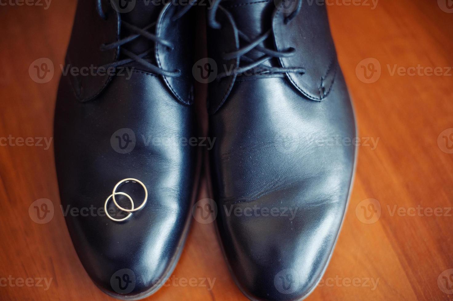 zapatos de hombre negro y anillos de boda foto