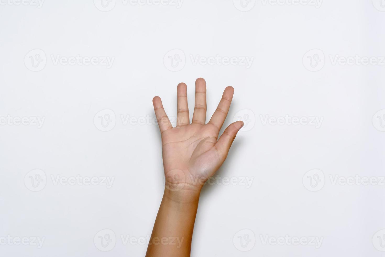 niño levantando cinco dedos en la mano sobre fondo blanco. foto