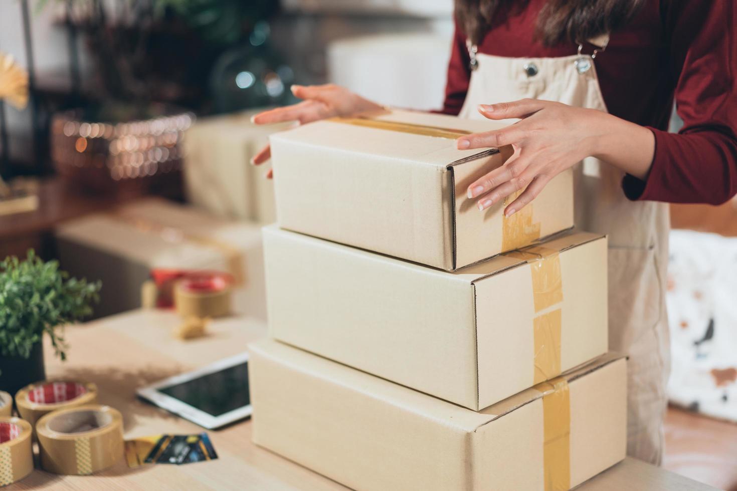 SME small business entrepreneur or shop owner packing boxes preparing customer order before shipping delivery. drop shipping commerce retail, startup business, freelancer working at home photo