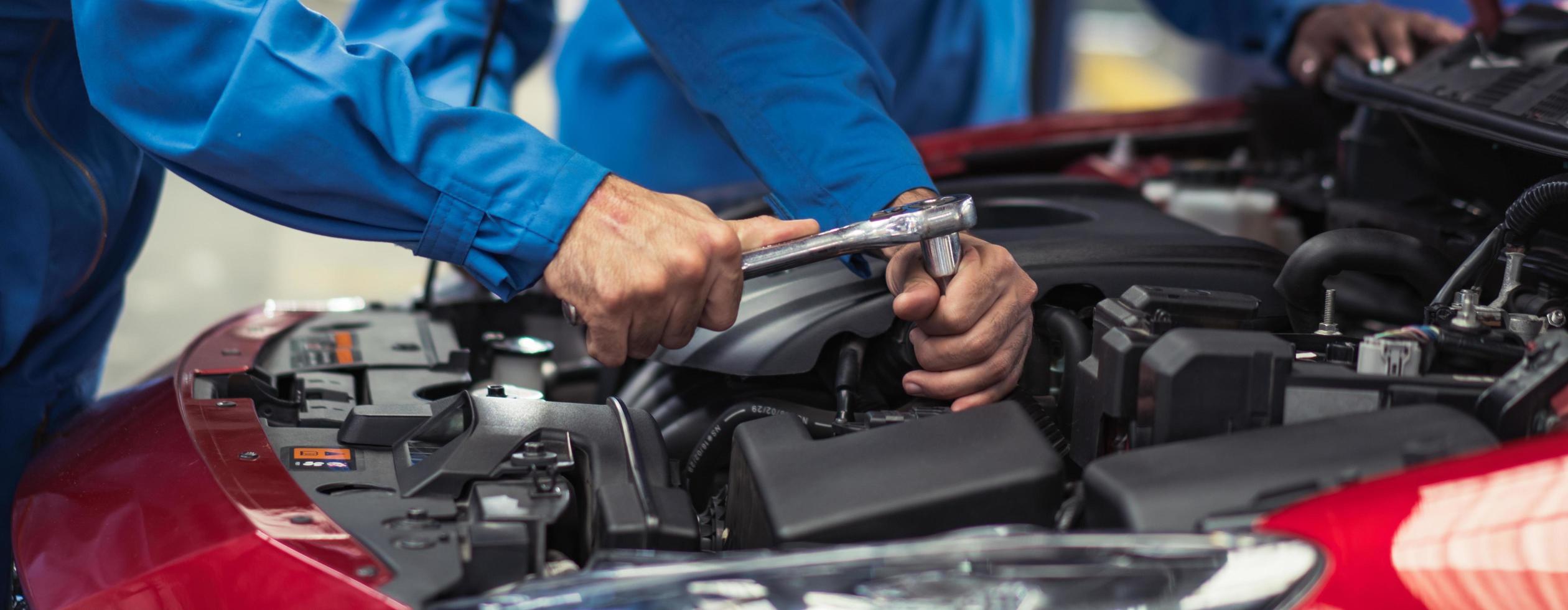 pancarta del mecánico de automóviles y el equipo revisando el estado de la pieza rota del daño del automóvil, diagnóstico y reparación del vehículo en el garaje automotriz, mantenimiento técnico del motor después del concepto de servicio foto