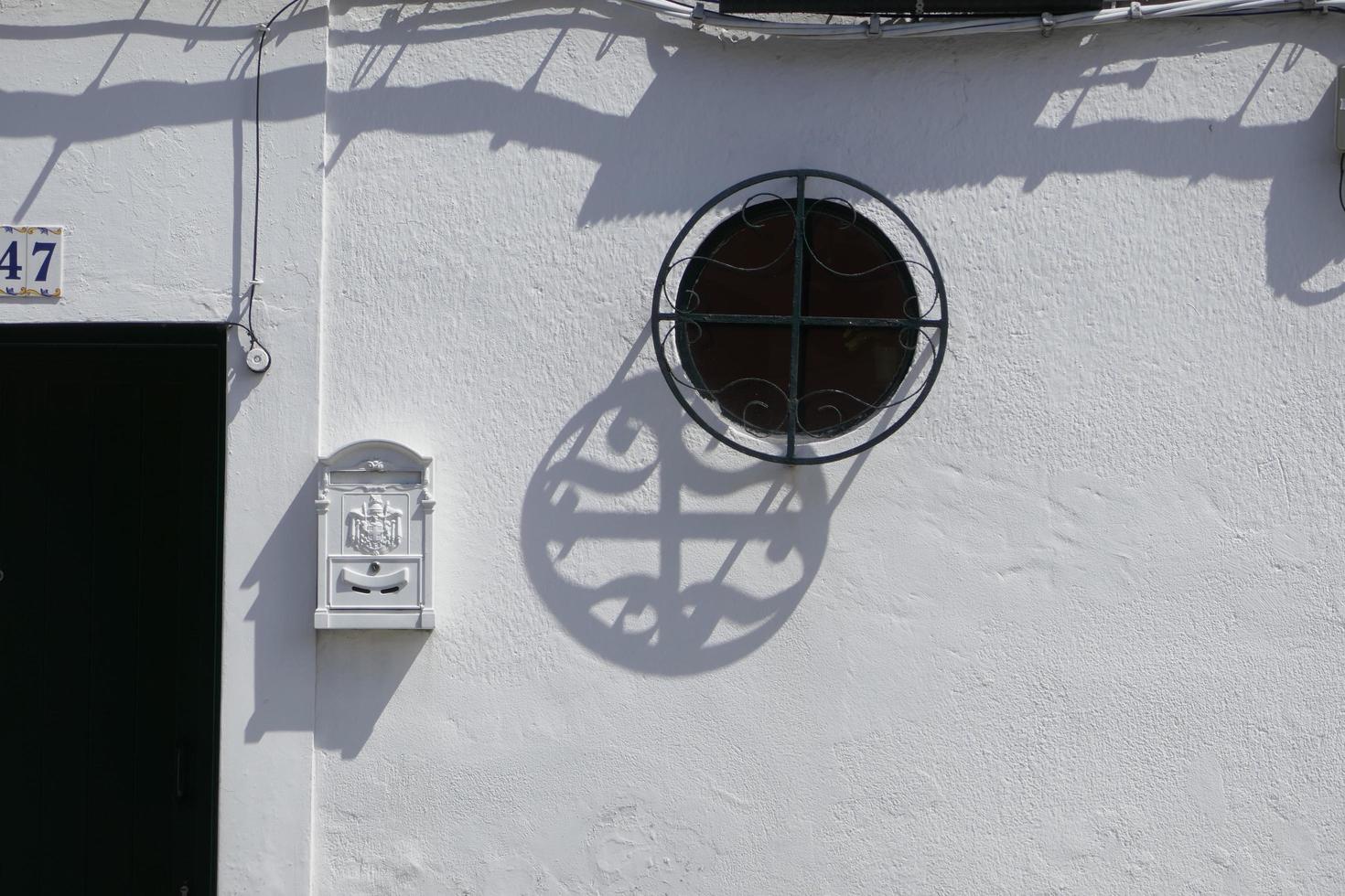 sombra de rejilla de ventana en una pared blanca foto