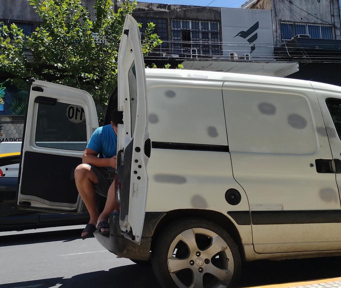 City of Buenos Aires, Argentina. February 14, 2022. Man sitting in the back of a van photo