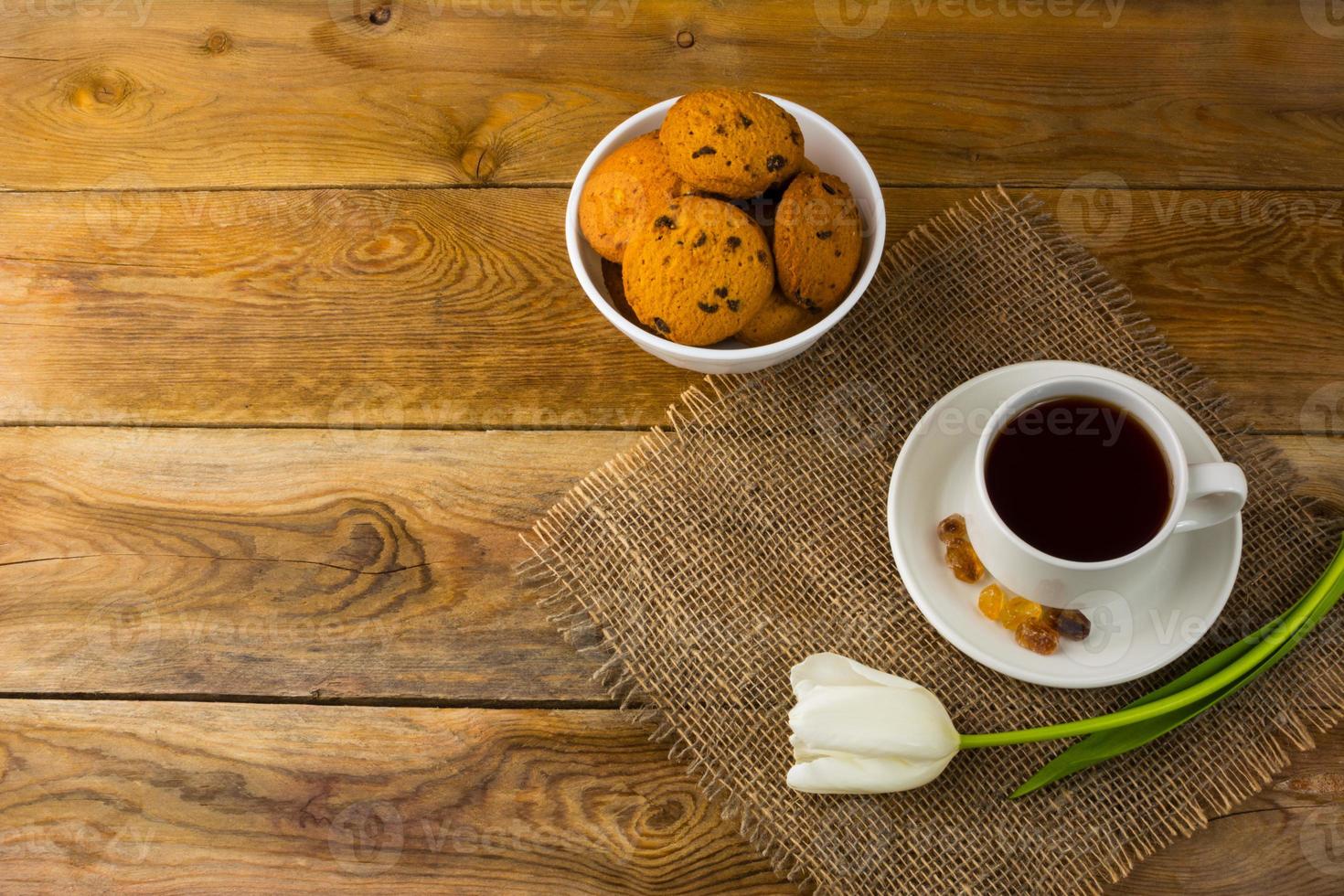 Tea cup and biscuits on sackcloth, top view photo